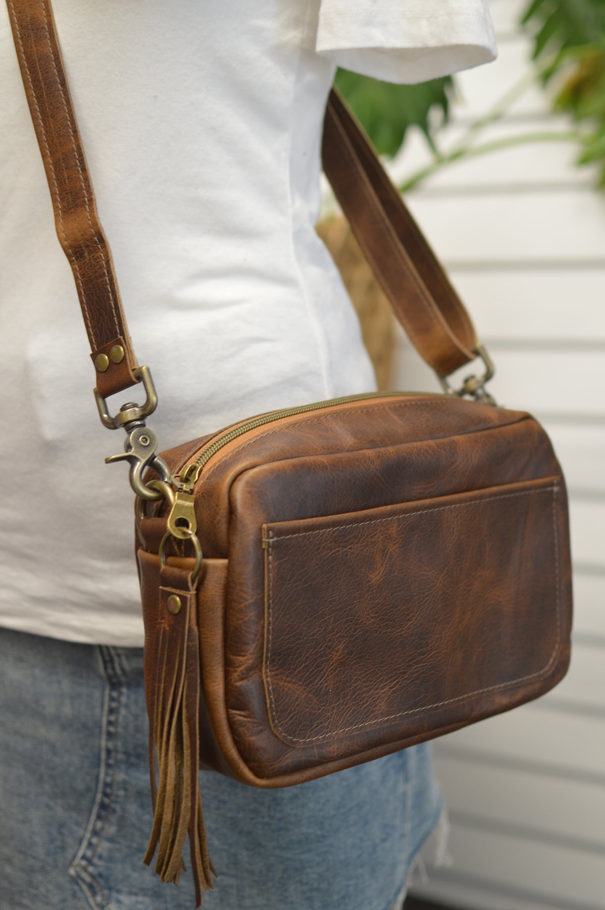 Square brown bison leather crossbody bag with front slip pocket, adjustable crossbody strap, gussets zipper panel