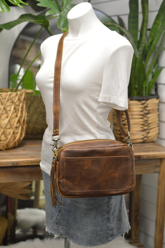 Square brown bison leather crossbody bag with front slip pocket, adjustable crossbody strap, gussets zipper panel