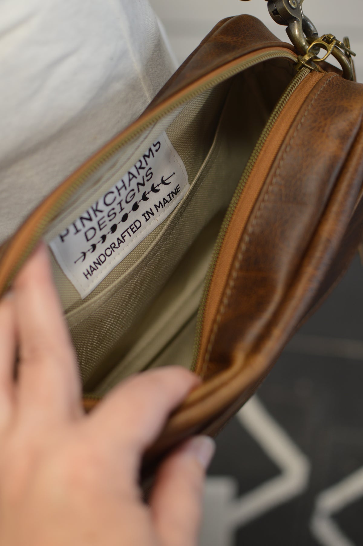 Square brown bison leather crossbody bag with front slip pocket, adjustable crossbody strap, gussets zipper panel